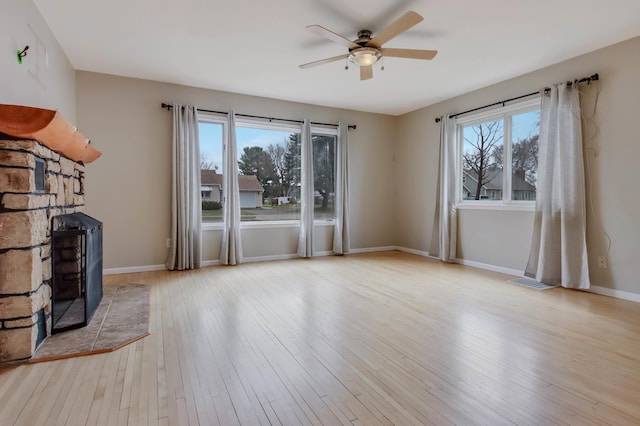 unfurnished living room with a ceiling fan, hardwood / wood-style floors, visible vents, and plenty of natural light