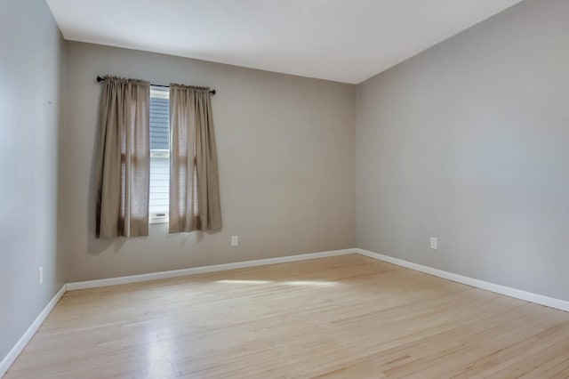 unfurnished room featuring baseboards and wood finished floors