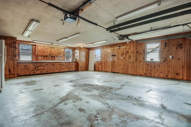 garage with wood walls and a garage door opener
