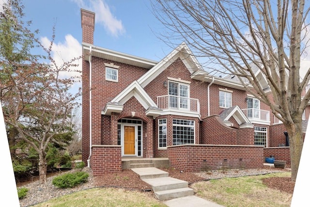 view of front of home with a chimney and brick siding