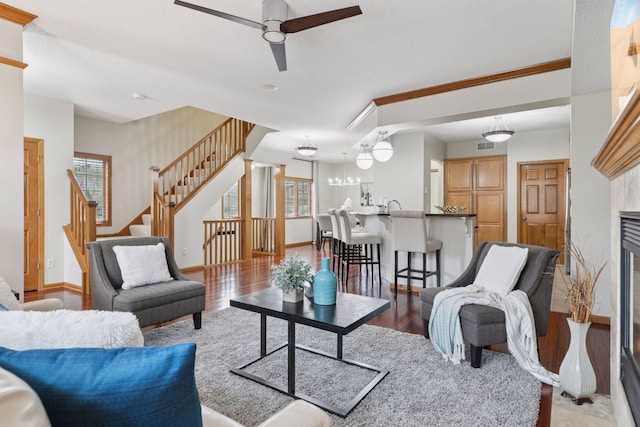 living room with light wood-type flooring, a fireplace, a healthy amount of sunlight, and stairway