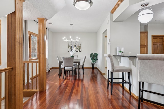 dining room featuring baseboards, a notable chandelier, ornate columns, and dark wood-type flooring