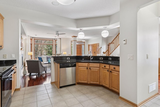 kitchen with visible vents, dark countertops, stainless steel dishwasher, a sink, and open floor plan