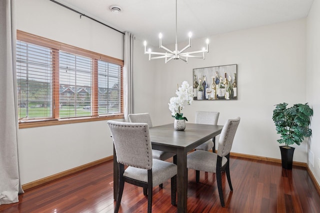 dining area with baseboards, dark wood finished floors, and a notable chandelier