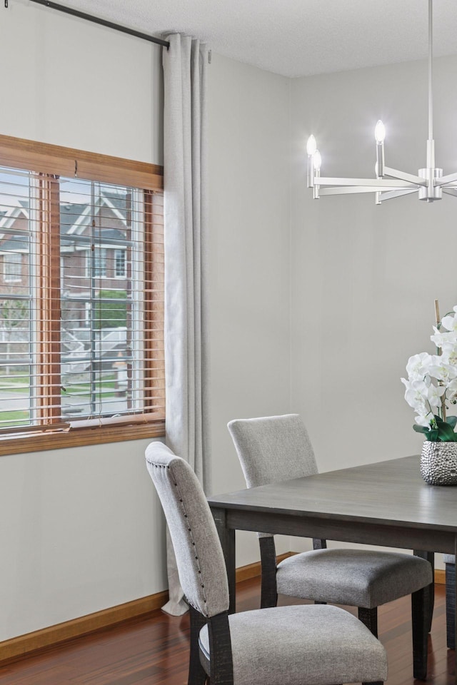 dining room with an inviting chandelier, baseboards, and wood finished floors