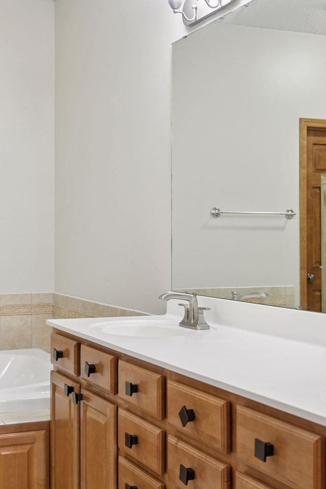full bath featuring vanity and a bath