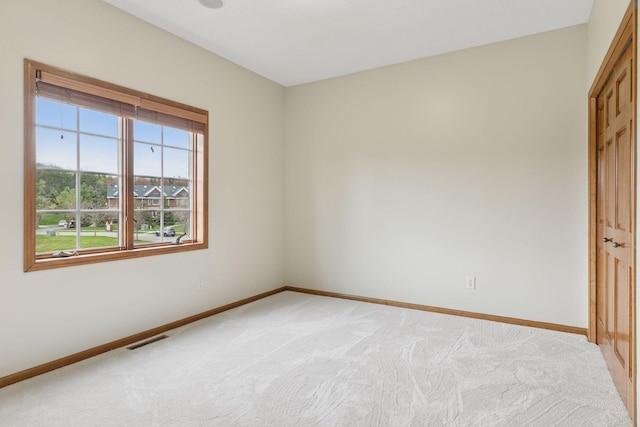 unfurnished bedroom featuring visible vents, baseboards, and light carpet