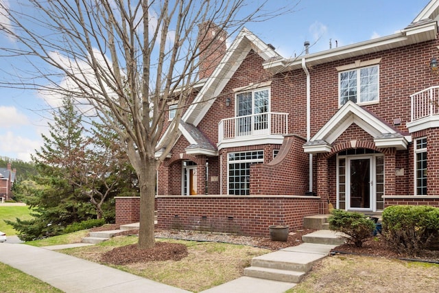 view of front of property with brick siding and a balcony