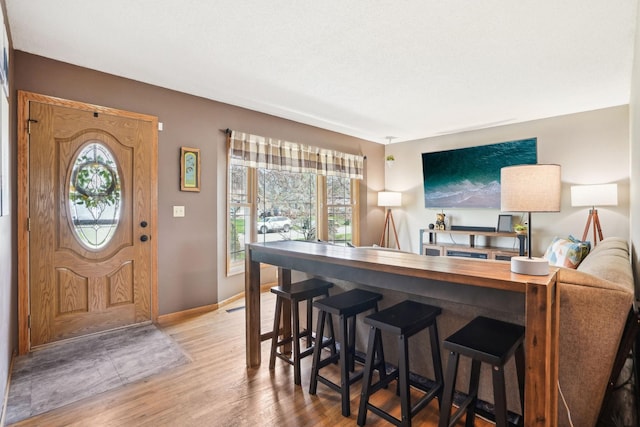interior space with a healthy amount of sunlight, baseboards, and wood finished floors