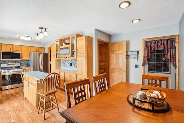 dining area featuring a textured ceiling and light wood-style flooring