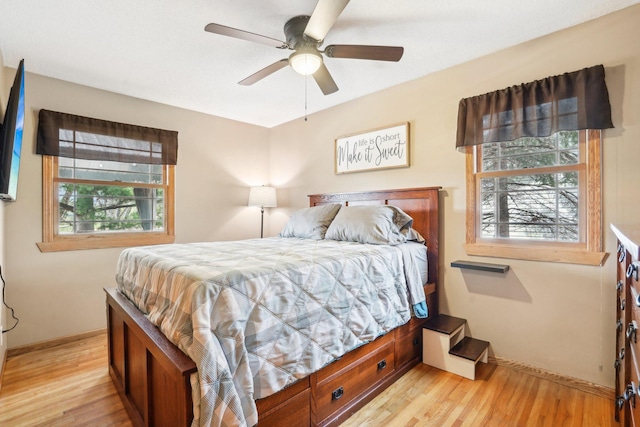 bedroom featuring baseboards, light wood finished floors, and ceiling fan