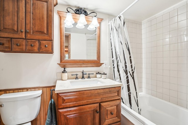 full bathroom with vanity, shower / tub combo with curtain, wainscoting, and toilet