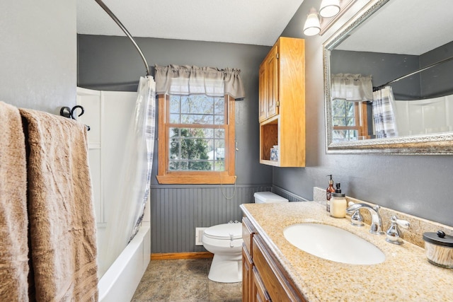 full bath featuring vanity, a wainscoted wall, toilet, and shower / bath combination with curtain