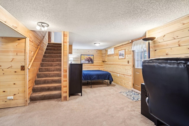 carpeted bedroom with wood walls and a textured ceiling