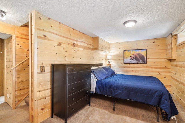 bedroom featuring carpet floors, wood walls, and a textured ceiling