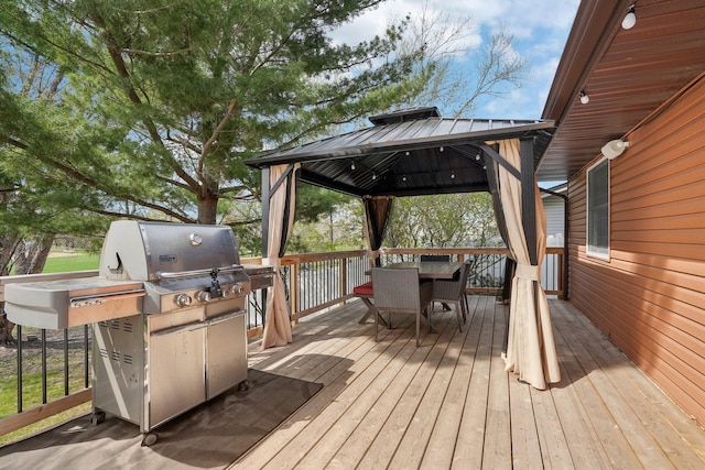 wooden terrace featuring grilling area, a gazebo, and outdoor dining space
