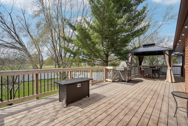 wooden terrace featuring a gazebo, outdoor dining space, and area for grilling