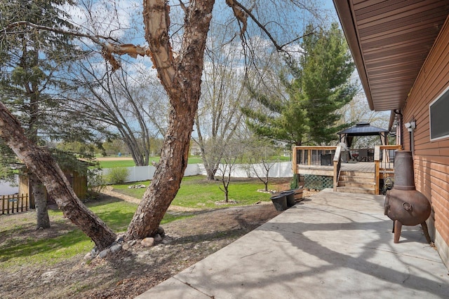 view of yard featuring a fenced backyard, a wooden deck, a gazebo, and a patio