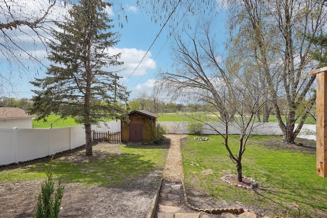 view of yard featuring a storage shed, an outbuilding, and a fenced backyard