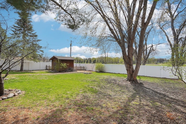 view of yard with a fenced backyard, an outdoor structure, and a shed