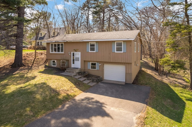 raised ranch featuring roof with shingles, an attached garage, driveway, and a front yard
