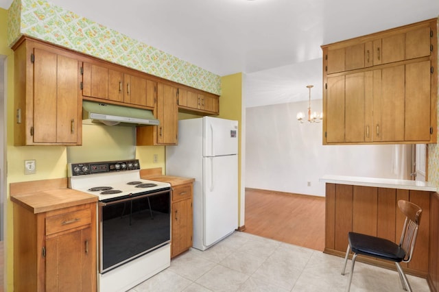 kitchen with brown cabinets, a notable chandelier, white appliances, light countertops, and under cabinet range hood