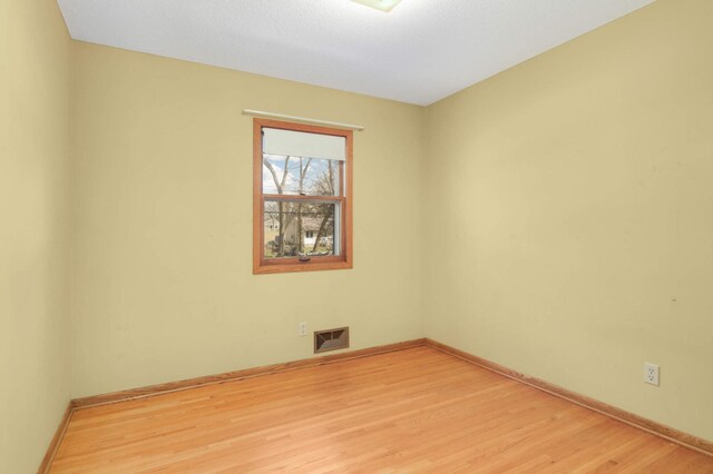 spare room with baseboards, visible vents, and light wood-type flooring