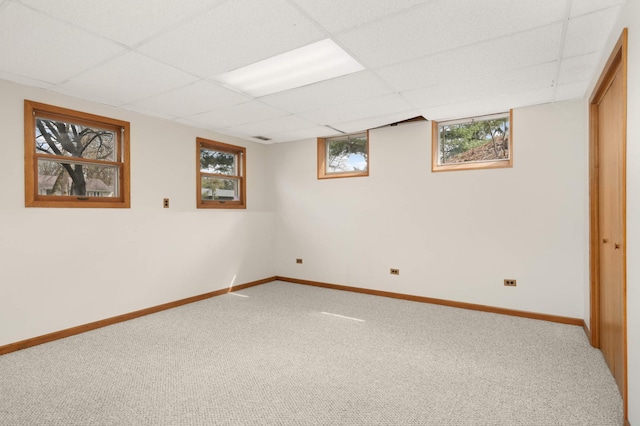 below grade area featuring carpet floors, baseboards, and plenty of natural light