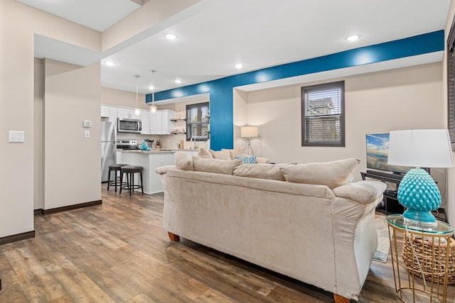 living area featuring recessed lighting, baseboards, and dark wood-style floors