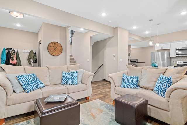 living area featuring recessed lighting, wood finished floors, and stairway
