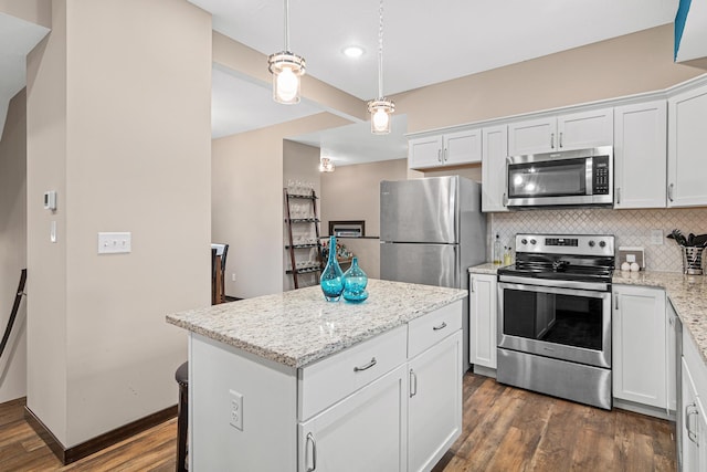 kitchen featuring appliances with stainless steel finishes, white cabinets, a center island, and dark wood-style floors