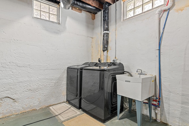 washroom featuring laundry area, washing machine and dryer, and a sink
