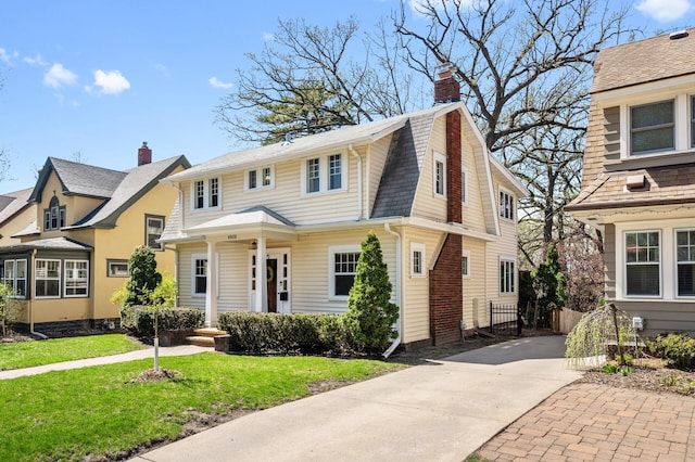 view of front of house featuring concrete driveway, fence, a chimney, and a front yard