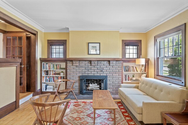 sitting room featuring crown molding, a brick fireplace, and wood finished floors