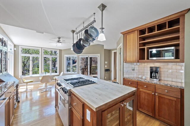 kitchen with appliances with stainless steel finishes, brown cabinets, and light wood finished floors