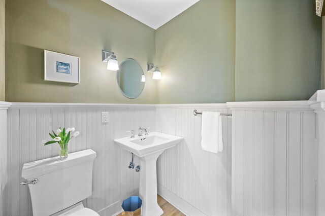 bathroom with a wainscoted wall and toilet