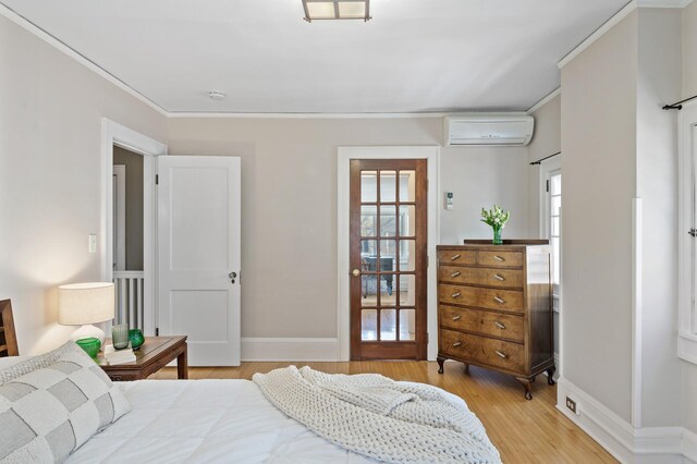 bedroom with crown molding, baseboards, wood finished floors, and a wall mounted air conditioner