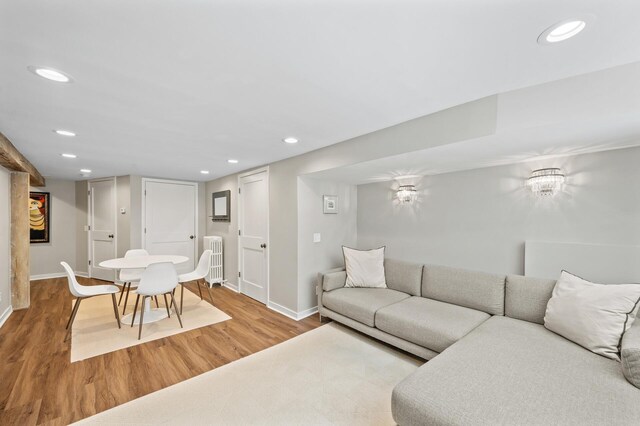 living area with baseboards, recessed lighting, radiator, and wood finished floors