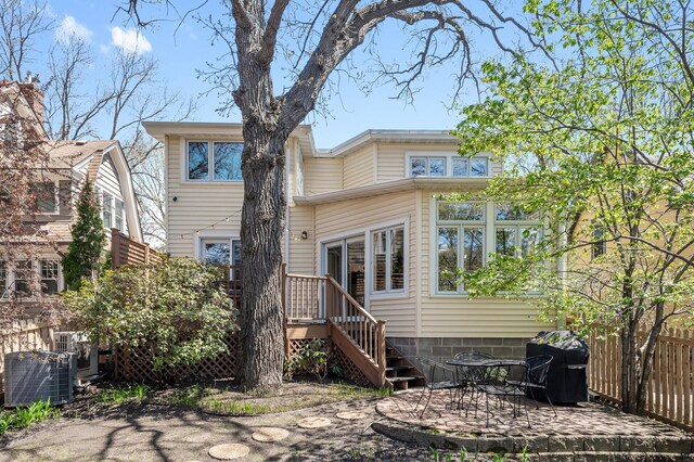 rear view of house featuring a patio, central AC, and fence