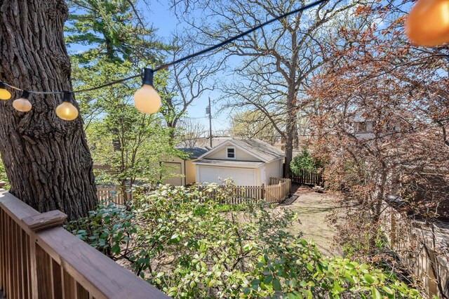 view of property exterior featuring a detached garage, fence, and an outbuilding