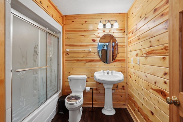 710 Rush Creek Ln, Rush City, MN 55069 - full bathroom featuring toilet, wood walls, wood finished floors, and bath / shower combo with glass door