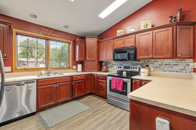 29107 Danel Ave, Randolph, MN 55065 - kitchen featuring appliances with stainless steel finishes, lofted ceiling, a sink, light wood-style flooring, and decorative backsplash