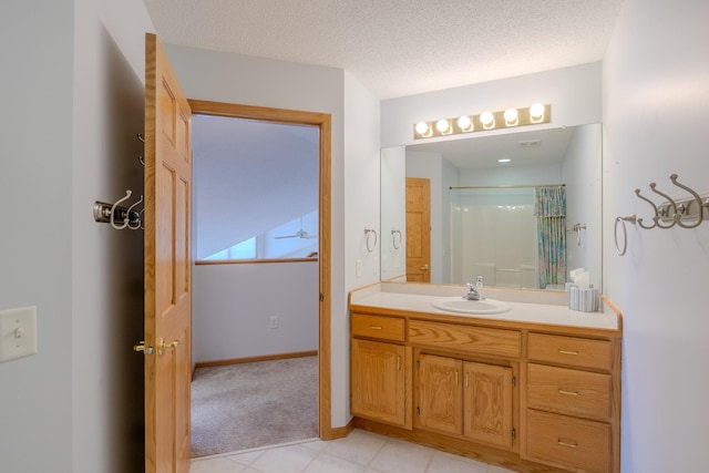 bathroom with ceiling fan, vanity, a textured ceiling, a shower with shower curtain, and baseboards