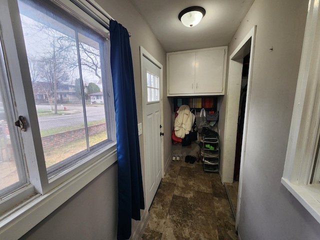 hallway with stone finish floors and plenty of natural light