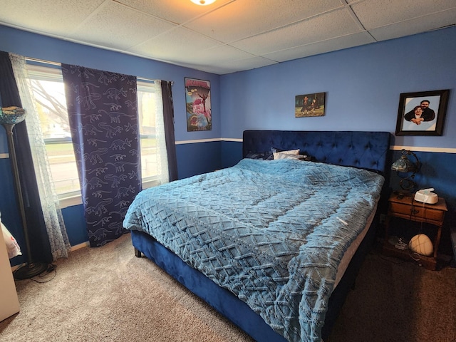 bedroom with carpet, a paneled ceiling, and baseboards
