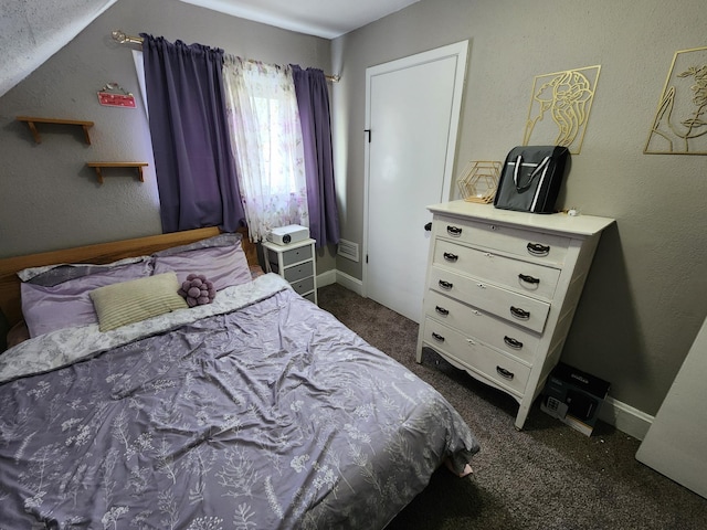 bedroom with dark colored carpet, baseboards, and vaulted ceiling