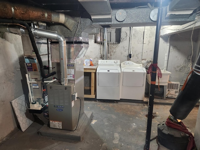 unfinished basement featuring washer and dryer, heating unit, and a sink