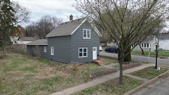 view of property exterior with roof with shingles and a chimney