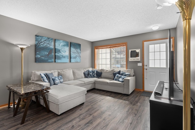 living room featuring dark wood-type flooring, a textured ceiling, and baseboards