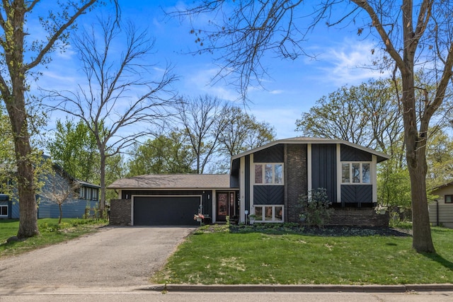1302 Birch Dr, Hudson, WI 54016 - view of front of house featuring brick siding, asphalt driveway, an attached garage, a front yard, and board and batten siding
